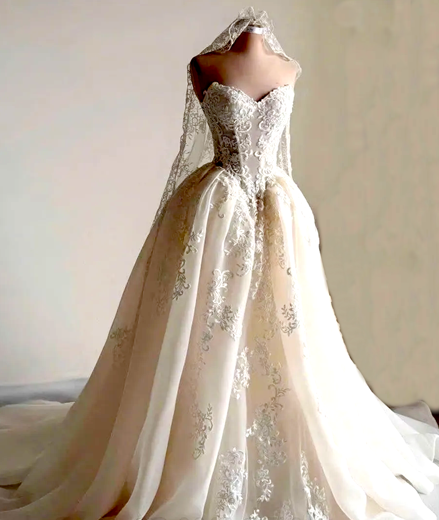 Embroidered lace wedding gown displayed on a dress form
