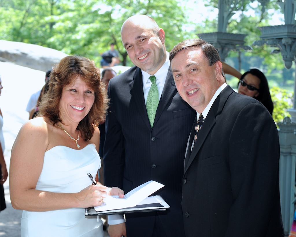 Newlyweds signing their marriage license with a NY Marriages wedding officiant